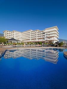 een groot wit gebouw met een groot zwembad met water bij H10 Taburiente Playa in Breña Baja