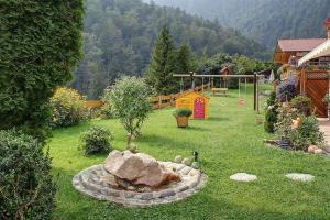 een tuin met een speeltuin met een boom in het gras bij Haus Holzner-Nagl in Schneizlreuth