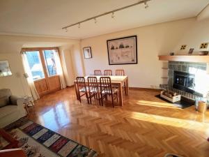 a living room with a table and chairs and a fireplace at Atico duplex Urb La Viña en Biescas in Biescas