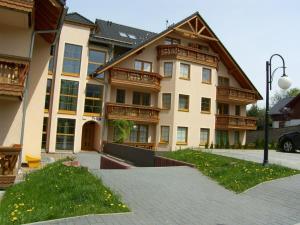 ein großes Apartmenthaus mit einem Gehweg davor in der Unterkunft Apartamenty EverySky - Prusa 2A - przyziemie in Karpacz