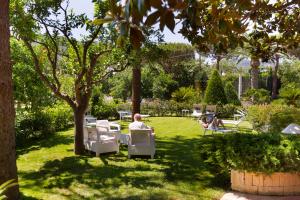 a person sitting in a chair under a tree at Hotel Alpha in Sant'Agnello