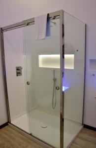 La salle de bains est pourvue d'une douche avec une porte en verre. dans l'établissement La Casa nel Borgo Antico, à Melfi