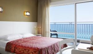 a bedroom with a bed with a view of the ocean at Hotel Alkyonis in Platamonas