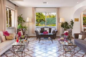 a living room with couches and tables at Hotel Alpha in Sant'Agnello