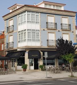 a large building with tables and chairs in front of it at Ribeira de Fefiñanes in Cambados