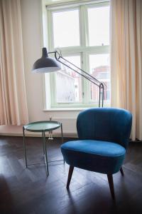 
a living room with a chair and a lamp at Gelkingehof Apartments in Groningen
