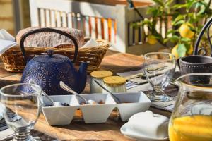 uma mesa com um pote azul e pratos sobre ele em Chambres d'hôtes Domaine de Ginouilhac em Le Taillan-Médoc