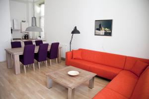 a living room with a red couch and a table at Gelkingehof Aparthotel in Groningen