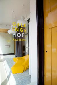 a room with yellow chairs and a chandelier at Gelkingehof Aparthotel in Groningen