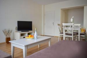 a living room with a white table and a tv at Flores Park in Sunny Beach