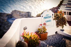 a sign on a wall with some flowers on it at Marizan Caves & Villas in Oia