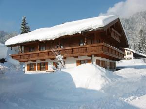 un edificio cubierto de nieve con un montón de nieve en Haus Hager en Schneizlreuth