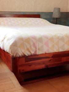 a bed with a wooden frame in a room at Apto Valentina Salou in Salou