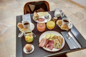 un tavolo con un piatto di prodotti per la colazione e bevande di Hôtel Sèvres Saint Germain a Parigi