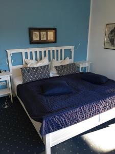 a bedroom with a bed with a blue wall at Haus Pamela in Neuharlingersiel