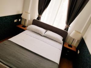 a bed in a room with a window and two lamps at Apto Valentina Salou in Salou