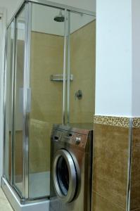 y baño con ducha y lavadora y secadora. en Casa di Alberta en Roma