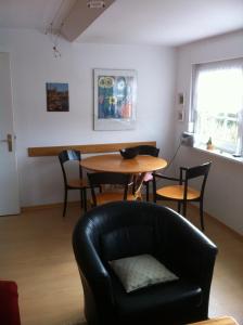 a living room with a table and a chair at Haus Pamela in Neuharlingersiel