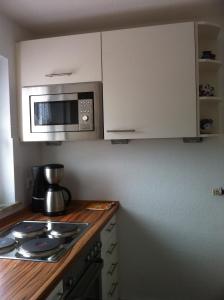 a kitchen with a counter top with a microwave at Haus Pamela in Neuharlingersiel +6 photos