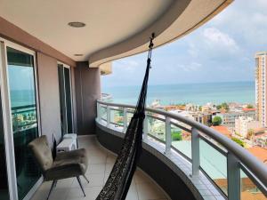 a hammock on a balcony with a view of the ocean at Studio Iracema - APTO 1502 in Fortaleza