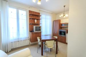 cocina con mesa y sillas y TV en Appartamento a 30 metri dal mare en Varazze
