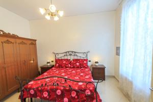 una camera con letto rosso e cuscini rossi di Appartamento a 30 metri dal mare a Varazze