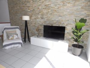 ein Wohnzimmer mit einem TV und einem Stuhl in der Unterkunft Apartamentos Medano - Duplex Sea Views in El Médano