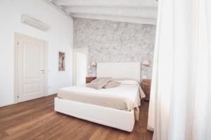 a bedroom with a white bed and a stone wall at La Favola Sirmione in Sirmione