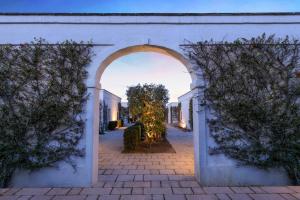 an archway leading into a courtyard with a tree at Rocco Forte Masseria Torre Maizza in Savelletri di Fasano