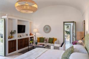 a living room with a couch and a tv at Rocco Forte Masseria Torre Maizza in Savelletri di Fasano