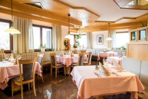 un ristorante con tavoli e sedie con tovaglie rosa di Hotel Föhrenhof a Naz-Sciaves