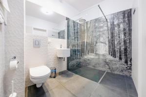 ein Badezimmer mit einem WC und einem Waldbild in der Unterkunft Luxury Long Island Suite in Danzig + 44 Fotos