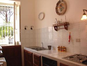 eine Küche mit einer Spüle, einem Herd und einem Fenster in der Unterkunft Villa Caferì in San Giorgio