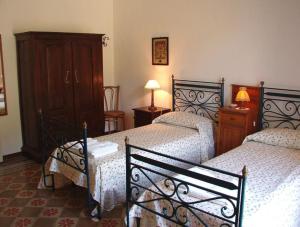 1 Schlafzimmer mit 2 Betten, einem Schrank und 2 Lampen in der Unterkunft Villa Caferì in San Giorgio