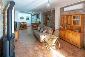 sala de estar con sofá y estufa de leña en Rincón de piedra BCN, en Corró de Vall