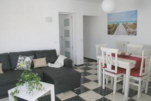 a living room with a couch and a table at Fantastic, 100 meters from the beach in Can Picafort