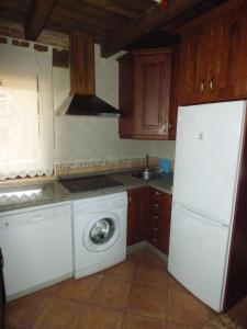 una cucina con lavatrice e frigorifero bianco di Un Rincón Salmantino a Navasfrías