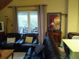 a living room with two leather couches and a window at Ferme Hurlet in Stavelot