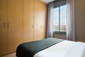 a bedroom with a bed and a large window at Bonavista Apartments - Pedrera in Barcelona