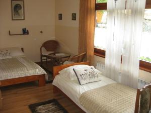 a bedroom with two beds and a window and a chair at Willa Dewajtis in Zakopane