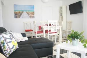 a living room with a couch and a table and chairs at Fantastic, 100 meters from the beach in Can Picafort