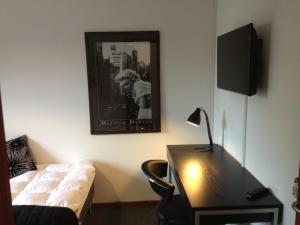 una camera con scrivania, letto, scrivania e lampada di Kanns Hotel ad Åkirkeby