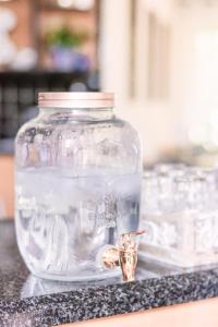 Um frasco de vidro com um objecto dourado à frente. em LilyRose Bed & Breakfast em Pretoria