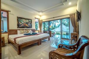 a bedroom with a bed and a large window at Pondok Putri Sari in Ubud