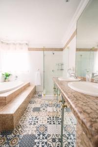 a bathroom with two sinks and two mirrors at LilyRose Bed & Breakfast in Pretoria