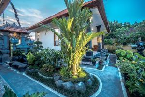 una casa con una palmera en el patio en Pondok Putri Sari, en Ubud