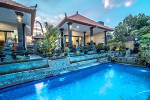 a swimming pool in front of a house at Pondok Putri Sari in Ubud