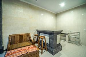 Una habitación con chimenea y dos taburetes en ella. en Pondok Putri Sari, en Ubud