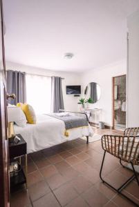 um quarto com uma cama e uma cadeira em LilyRose Bed & Breakfast em Pretoria