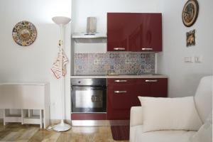 a kitchen with red cabinets and a stove at La maison de Julie in Vico Equense